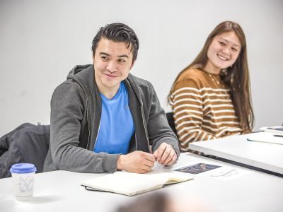 Two participants with notebooks in front of them, smiling